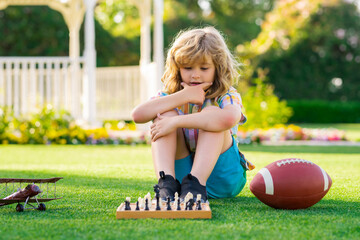 Dream kids and childhood concept. Kid playing chess and having fun outdoor on backyard or summer...