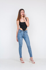 Confident young Asian woman in fashionable attire posing against a white background