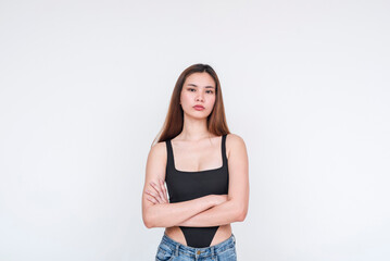 Young Asian woman in a black bodysuit posing with confidence against a white background