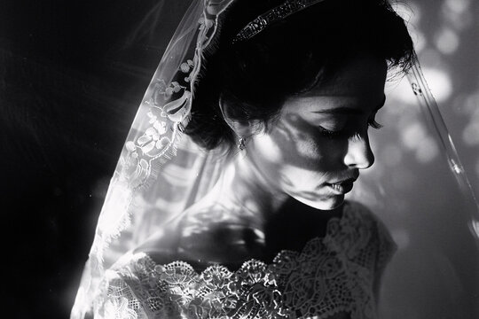 The photo captures a veiled bride in a monochrome palette, symbolizing the purity, mystery, and timeless essence of a wedding day