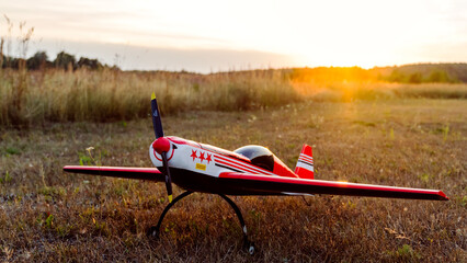 model of a radio-controlled airplane or drone on a field at sunset