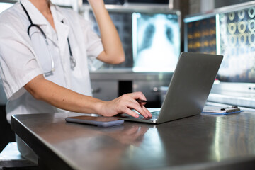 Doctor woman working with laptop check up x-ray film in medical laboratory at hospital. Anatomy...