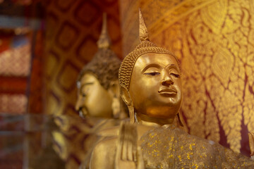 Head of Buddha statue with yellow light in Temple of Thailand. Golden buddha statue in temple of...