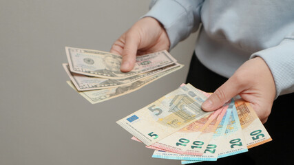 Exchange US dollar or American dollars (USD) for EUR money. Woman counts banknotes. Woman hands...