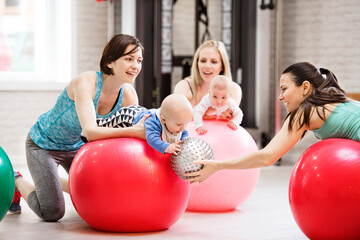 Baby movement class. Parents helping babies to improve motor skills, proper movement on fitball....