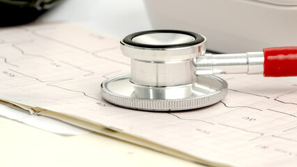 Stethoscope on heart cardiogram, heart examination concept