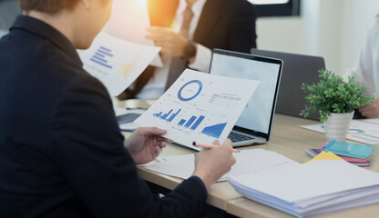 Businessman working on laptop with analysis report chart and sitting in office.