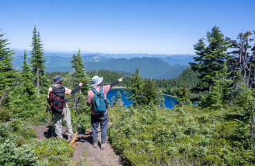 Two people pointing the direction of the Summit Lake trail. Mt Rainier National Park. Washington State. USA.