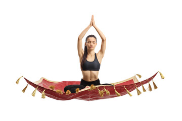 Young woman exercising yoga on a magic carpet