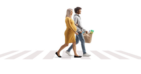Man and pregnant woman crossing a street at a pedestrian crossing