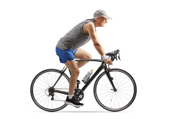 Full length profile shot of an elderly man in sportswear riding a bicycle