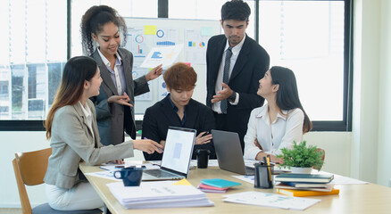 Asian group of people working with documents have financial or marketing charts on a board room...