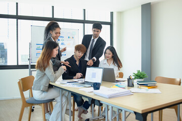 Asian group of people working with documents have financial or marketing charts on a board room table at a business presentation or seminar.
