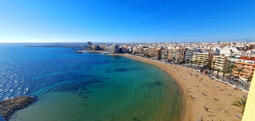Panorama of the sea coast with a sandy beach in Spain, Torrevieja, Mediterranean Sea. Sea coastline. Beautiful coastline view from above. Summer vacation at sea, vouchers, tour,  vacation, travel.