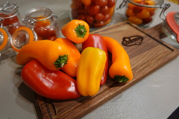 A wooden cutting board with a variety of peppers on it