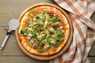Board with delicious vegetarian pizza on wooden table, top view