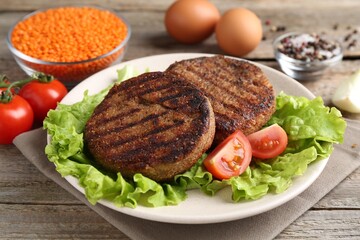 Vegetarian product. Tasty lentil cutlets served on wooden table, closeup