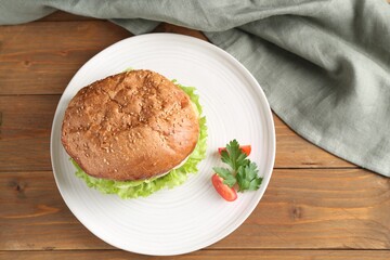 Delicious vegetarian burger served on wooden table, top view