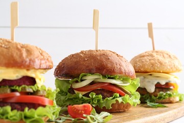 Delicious vegetarian burgers served on wooden board