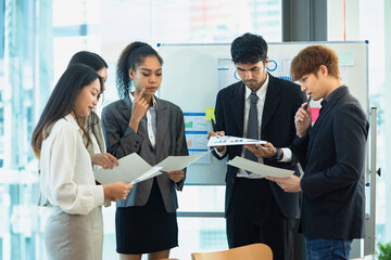 Asian group of people working with documents have financial or marketing charts on a board room at...
