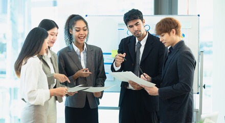 Asian group of people working with documents have financial or marketing charts on a board room at a business presentation or seminar.