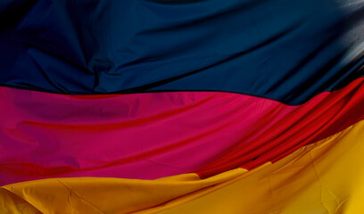Flag of Germany blowing in the wind. Close up waving flag of Germany. Flag symbols of Germany