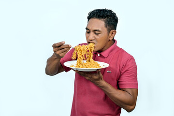 An Asian man is eating noodles