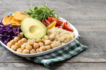 Healthy salad with avocado,lettuce,tomato and chickpeas on white wooden table. Copy space