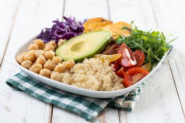 Healthy salad with avocado,lettuce,tomato and chickpeas on white wooden table