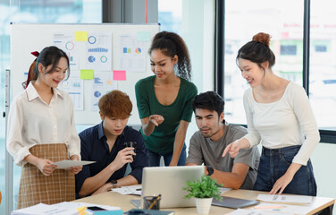 Asian group of people working with documents have financial or marketing charts on a board room table at a business presentation or seminar.