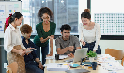 Asian group of people working with documents have financial or marketing charts on a board room table at a business presentation or seminar.