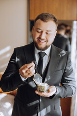 A man in a suit is holding a ring in his hand