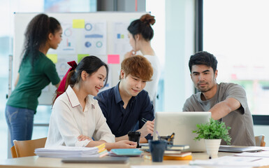 Asian group of people working with documents have financial or marketing charts on a board room table at a business presentation or seminar.