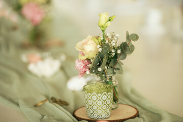 Eine Tischdekoration mit frischen Blumen in mintgrünen Farben.