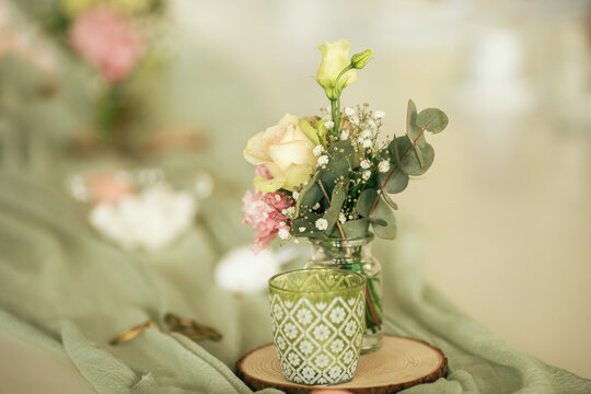 Eine Tischdekoration mit frischen Blumen in mintgr&uuml;nen Farben.