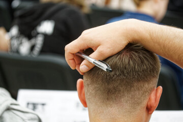 High school student reflecting during an exam or test and putting his hand on his head....