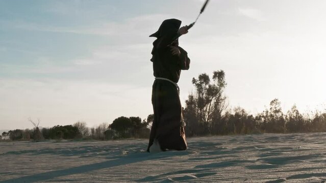 Franciscan father rotates nunchucks in the air