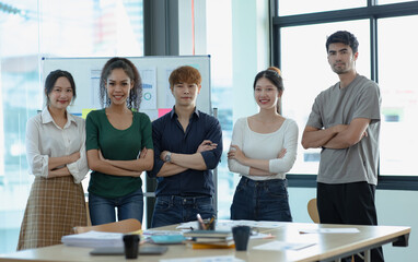 Asia young creative people in smart casual wear looking at camera in office workplace.