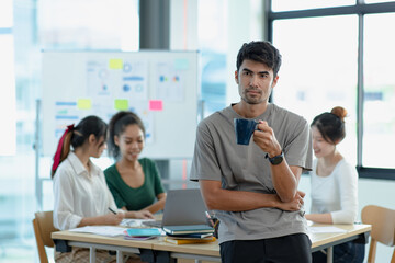 Asia young creative people in smart casual wear looking at camera in office workplace.