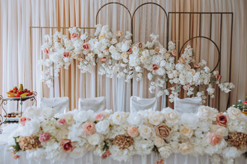 the presidium of the bride and groom at the wedding is decorated with various pink and white rose flowers. Preparation for the wedding celebration