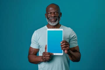 Digital mockup afro-american man in his 50s holding a tablet with a completely blue screen