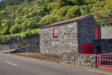 Beautiful houses made of black volcanic basalt stone. Azores. Pico Island at spring on Atlantic...
