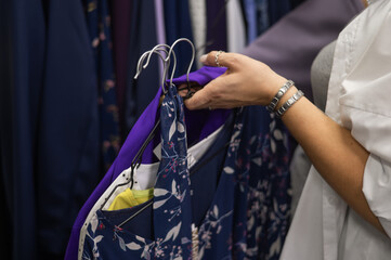 Close-up of woman's hands with hangers in a clothing store. 