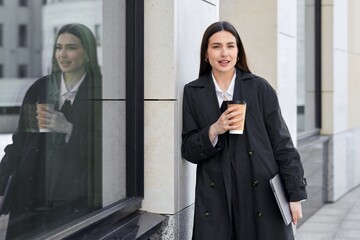 Young attractive businesswoman walking around the city during a break on the street