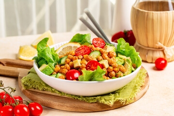 Kitchen table with mediterranean chickpea salad. Chickpea and paprika baked beans, lettuce,...