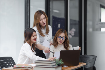 Group of young asian businesswoman working and brainstorming in workshop and analyzing marketing reports startup project infographics in the office.