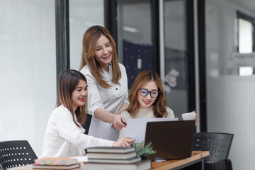 Group of young asian businesswoman working and brainstorming in workshop and analyzing marketing reports startup project infographics in the office.