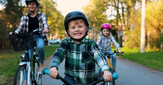 happy young boy riding a bicycle together with family