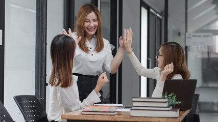 Group of young asian businesswoman working and brainstorming in workshop and analyzing marketing reports startup project infographics in the office.