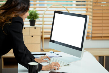 Cropped shot female entrepreneur using computer with blank screen at workplace